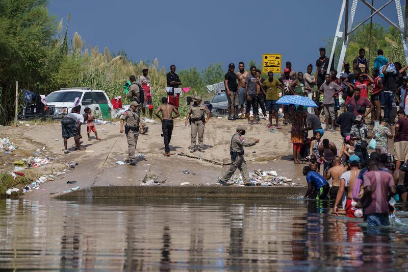 A state trooper addresses a group of migrants, many from Haiti, who are crossing into Del Rio, Texas, from Mexico on Saturday, AFP