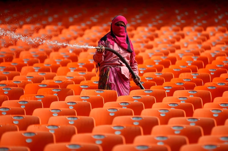 A worker cleans the seats in the stands at Narendra Modi Stadium. Reuters