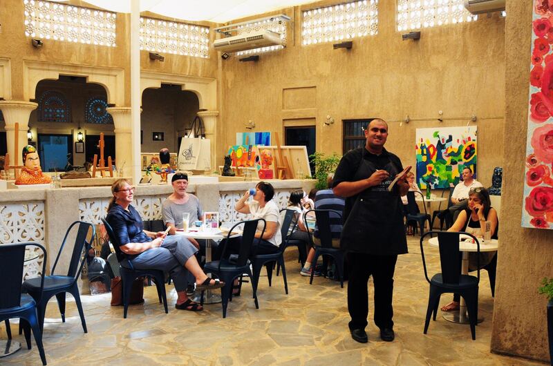 Emirati student and artist Abdullah Lutfi checks on visitors at a café at Mawaheb, a Dubai non-profit art studio for people with special needs. The studio encouraged the artists with disabilities to interact and communicate with people. Courtesy: Mawaheb