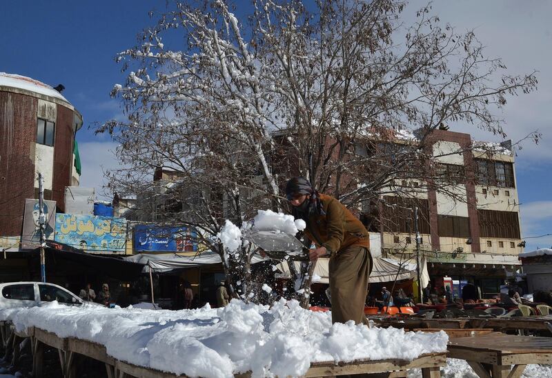 A vendor removes snow from his stall after heavy snowfall in Quetta. AP Photo