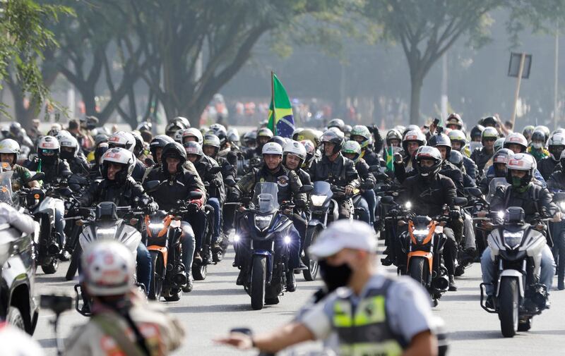 Brazil's President Jair Bolsonaro, center, takes part in a caravan of motorcycle enthusiasts who gathered in a show of support for Bolsonaro, in Sao Paulo, Brazil, Saturday, June 12, 2021. (AP Photo/Marcelo Chello)