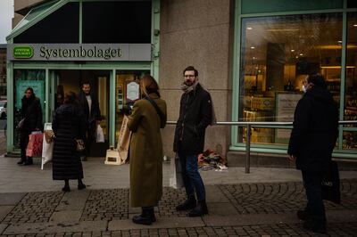 Customers stand in line to enter a "Systembolaget", the government-owned chain of liquor stores, in Gothenburg, Sweden, on Saturday, Dec 19, 2020. Sweden's Prime Minister Stefan Lofven has promised to fix the societal flaws exposed by the coronavirus once the nation has emerged from the pandemic. Photographer: Fredrik Lerneryd/Bloomberg