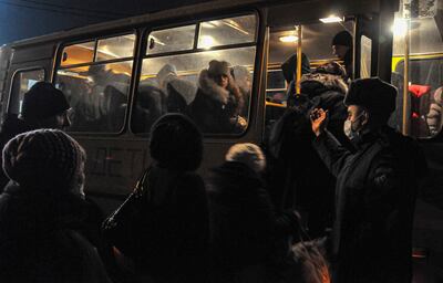 Residents of the self-proclaimed Donetsk People's Republic board a bus at a customs post in Rostov, Russia, on February 19, 2022. EPA