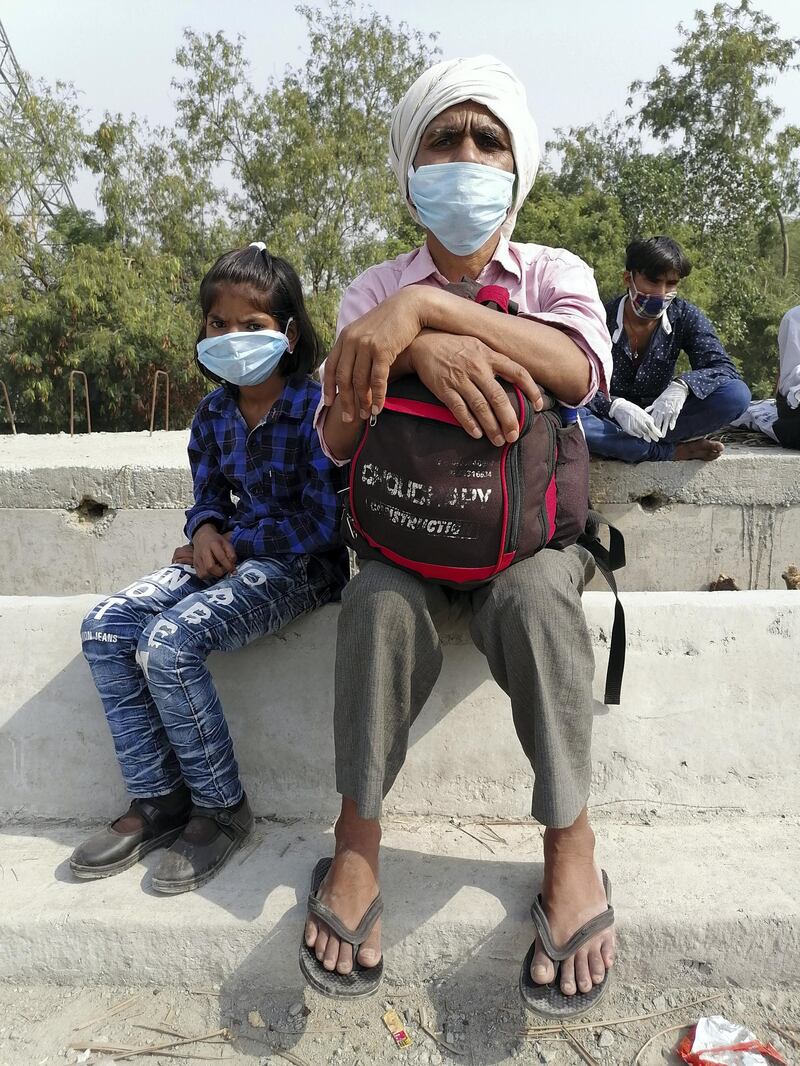Sudarshan Chauhan, 55, taking a break with his granddaughter on National Highway 24.  Taniya Dutta/The National
