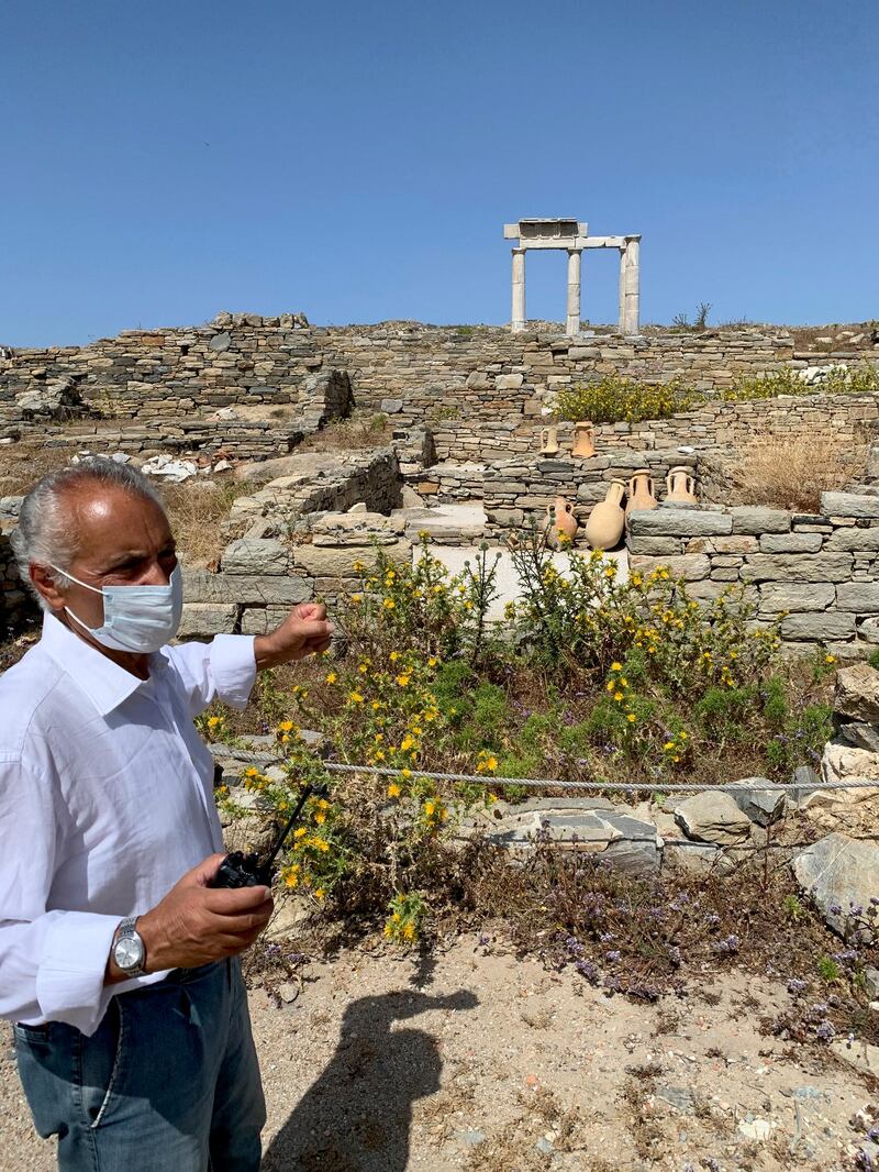 An Archaeological Service worker wears a face mask on the island of Delos, an ancient center of religious and commercial life, in Greece. The site is open for day trips for visitors on vacation on the nearby island of Mykonos. AP photo