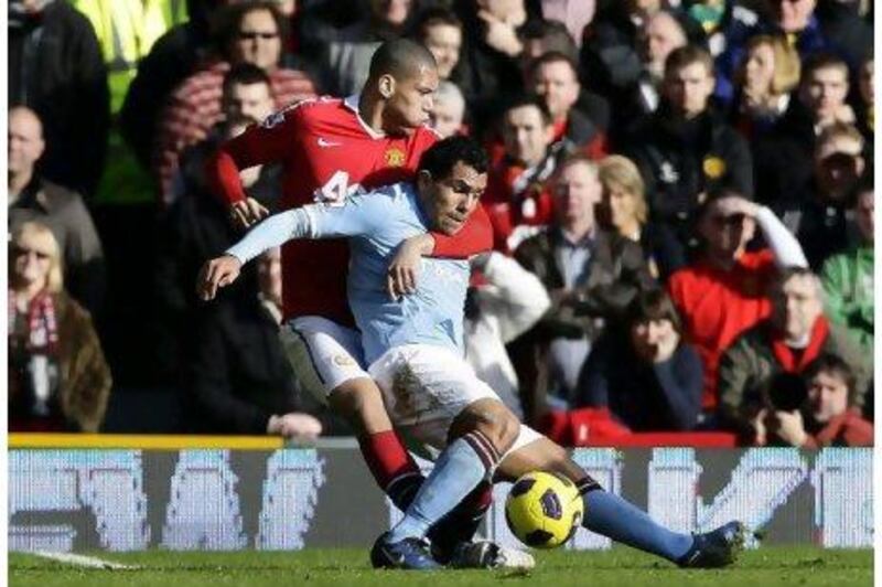 Carlos Tevez struggles to fend off the challenge of Chris Smalling, who put in a commanding performance for United.
