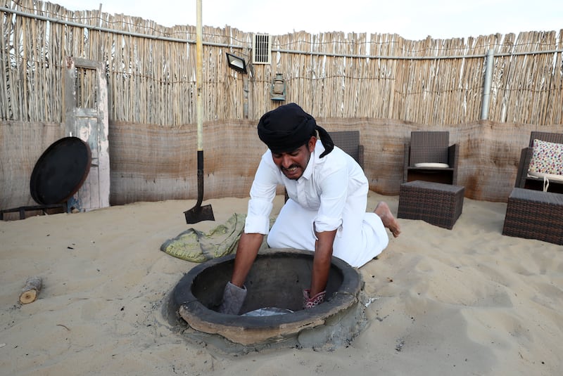 One of her helpers, Salim, prepares food in the tandoor