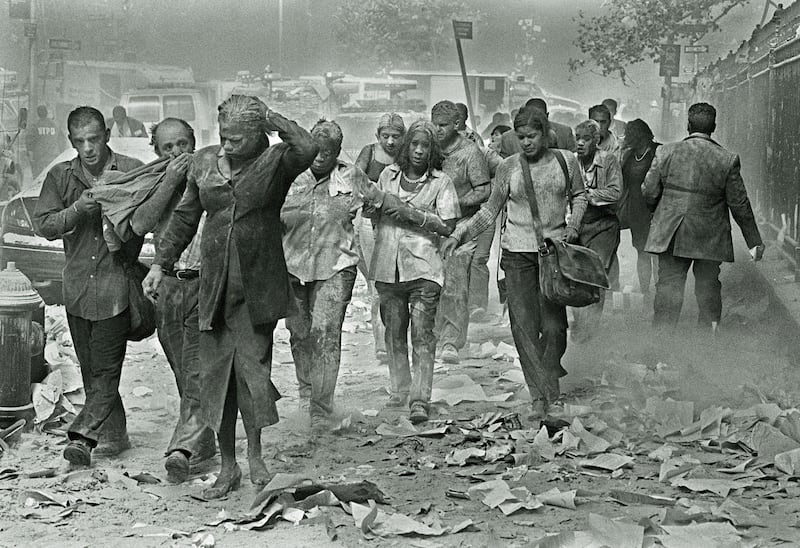 People covered in ash make their way through dust and debris after the South Tower of the World Trade Centre collapsed. Photo: Keystone/Zuma/Shutterstock (1450286a)