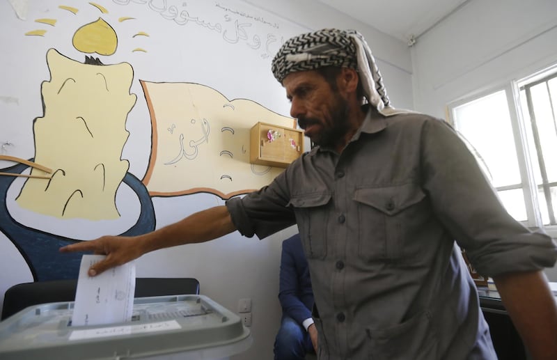 A man casts his ballot for Syria's first local elections since 2011, on September 16, 2018 in the southern Eastern Ghouta, on the eastern outskirts of the capital Damascus. Polling booths opened at 7:00 am (0400 GMT) across government-held parts of the country and will be open for 12 hours, with a potential five-hour extension depending on turnout, reported state news agency SANA. / AFP / LOUAI BESHARA
