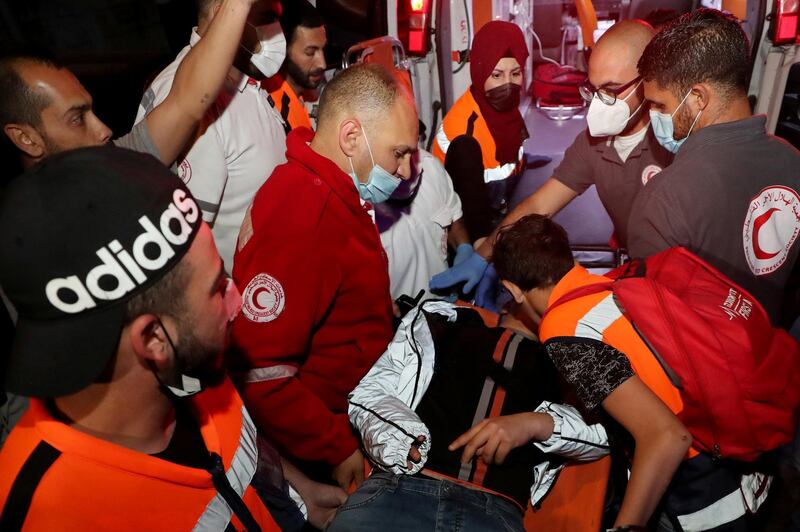 A Palestinian protester, who was injured during scuffles with Israeli police, is carried on to an ambulance in the Sheikh Jarrah neighbourhood of East Jerusalem. Reuters