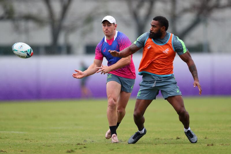 Australia's  Bernard Foley, left, releases a pass under pressure from Marika Koroibete. Getty