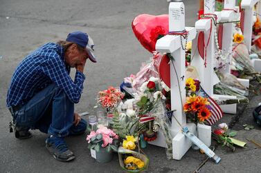 Antonio Basco cries beside a cross at a makeshift memorial near the scene of a mass shooting at a shopping complex, in El Paso, Texas. AP Photo/John Locher