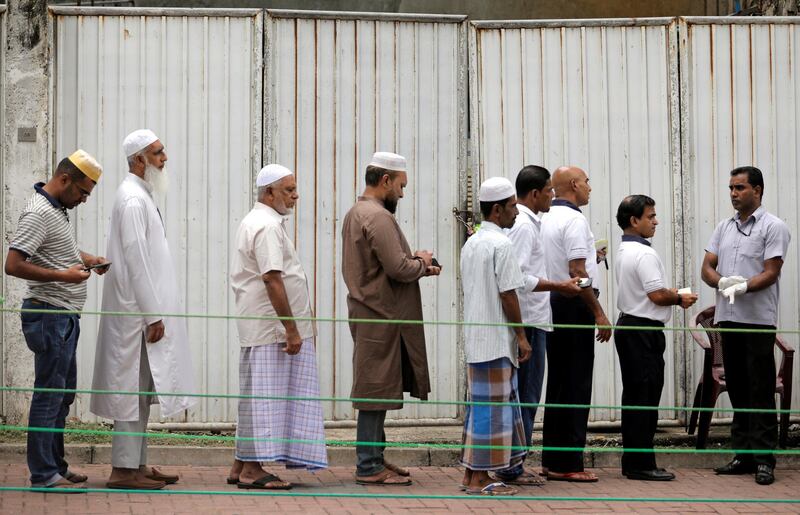 Muslim devotees wait in a line for security check near a mosque in Colombo. Reuters