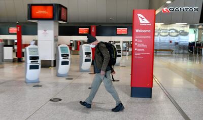 A traveller walks through a deserted Qantas terminal at Melbourne Airport as the Australian airline Qantas cited a "diabolical" year caused by pandemic travel restrictions. AFP