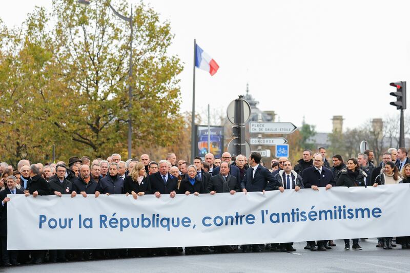 Former presidents Nicolas Sarkozy, fifth left, and Francois Hollande, ninth left, join other senior French figures to march behind a banner that reads 'For The Republic, Against anti-Semitism' during a demonstration in Paris on Sunday. AP