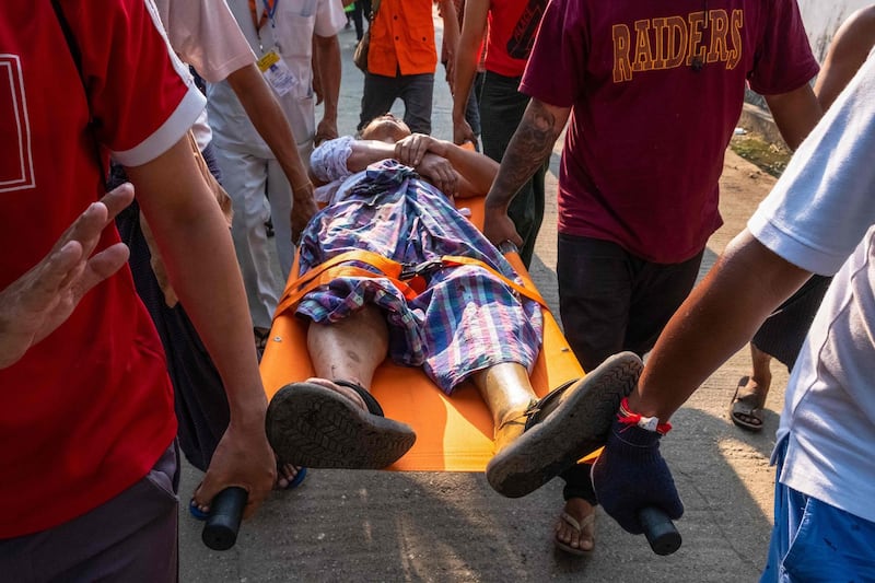 An injured person is carried away after being shot with rubber bullets, as security force destroyed barricades erected by protesters against the military coup, in Yangon, Myanmar. AFP