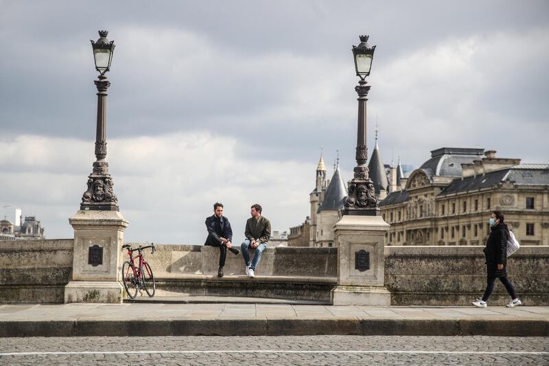 People on Pont Neuf bridge next to the river Seine in Paris, France. New lockdown measures include the closure of non-essential businesses, but people are allowed outdoors within a 10-kilometre radius of one's home without time restrictions. EPA