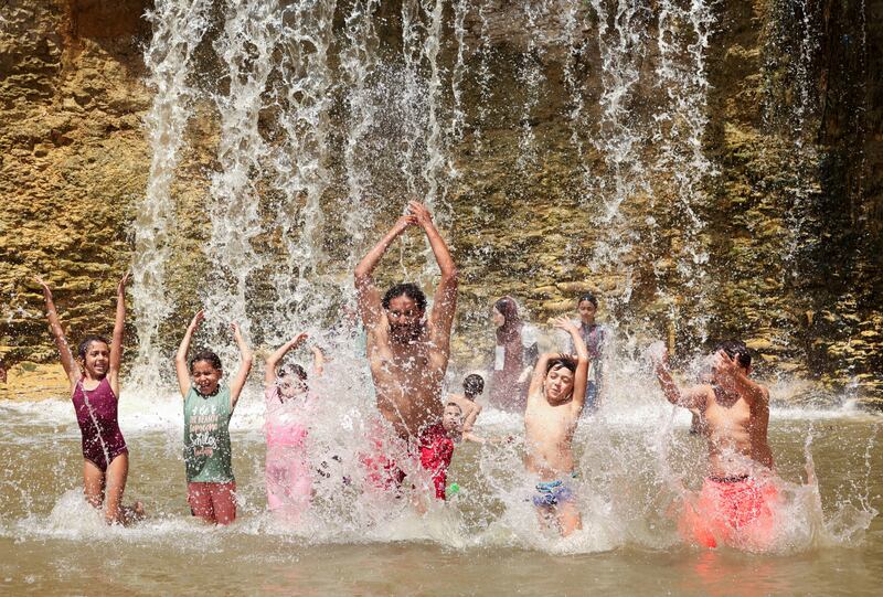 People play at the Wadi El-Rayan waterfalls, amid a heatwave in Al Fayoum Governorate, southwest of Cairo. Reuters