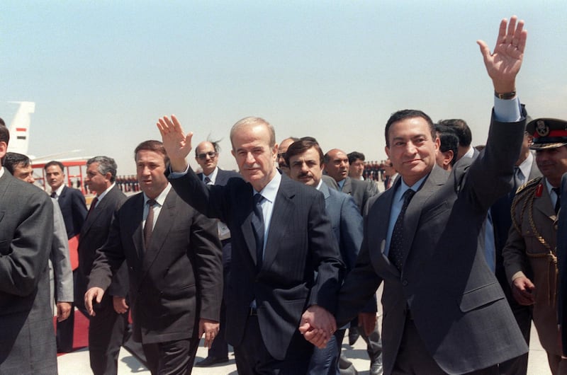 Syrian President Hafez el Assad (L) and Egyptian President Hosni Mubarak hold hands at airport 02 May. Mubarak is starting a two-day official visit, the first by an Egyptian president in 13 years. (Photo by NABIL ISMAIL / ARCHIVES / AFP)