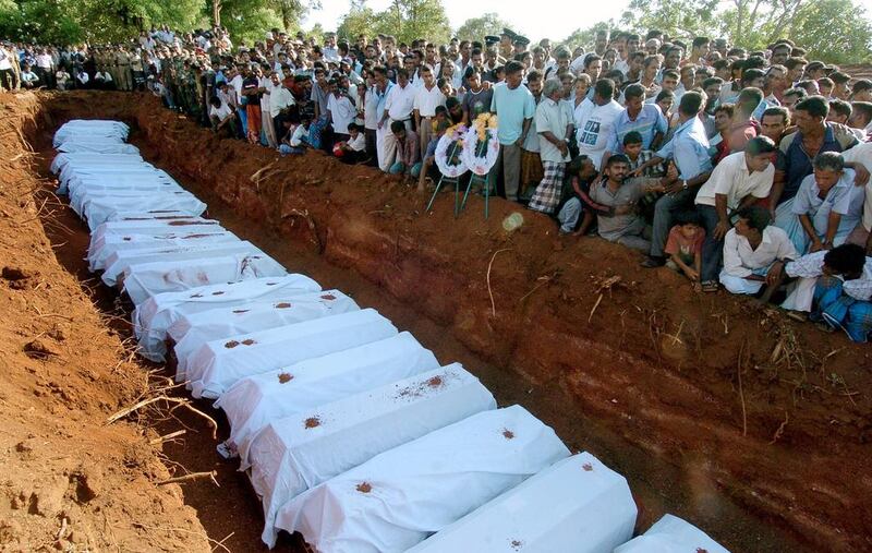Sri Lankan mourners burying coffins with 61 victims killed in a bomb attack at Kebitogollewa in northcentral Sri Lanka in June 2006.  Six years after the end of a bloody civil war, Sri Lanka this week took historic steps to confront its traumatic past.  Lakruwan Wanniarachchi / AFP Photo