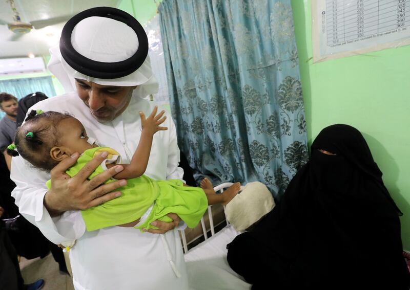 The UAE's Humanitarian Operations Director for Yemen, Saeed Al Kaabi carrying a Yemeni child diagnosed with malnutrition at a hospital in Mukalla. AFP