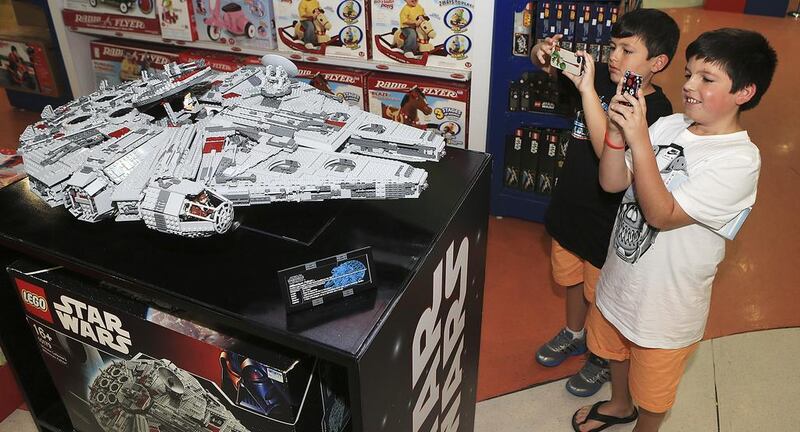 Brothers Zekri, left, and Halim Sadiku snap photos of the Dh19,999 Lego Millennium Falcon currently on display at The Toy Store in Dubai’s Mall of the Emirates. Sarah Dea / The National