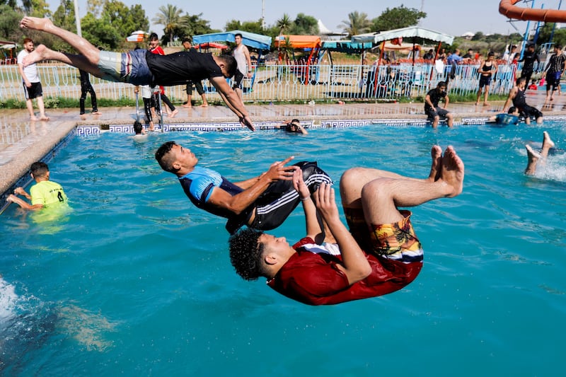 Men jump into the pool to cool down. Reuters