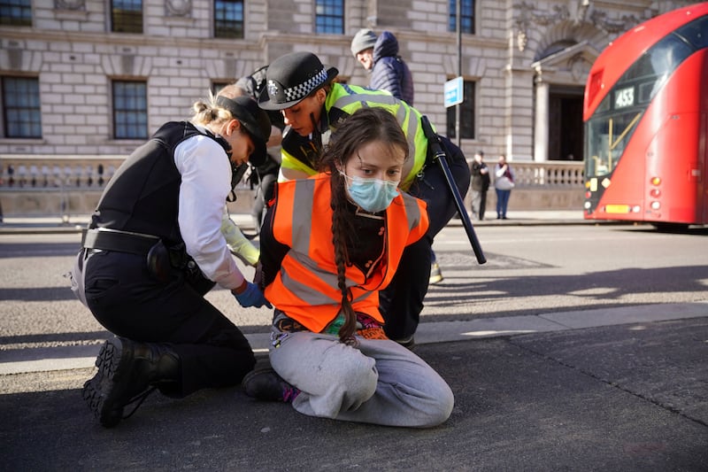 A Just Stop Oil protester is handcuffed and removed by police while blocking Whitehall in central London. AP
