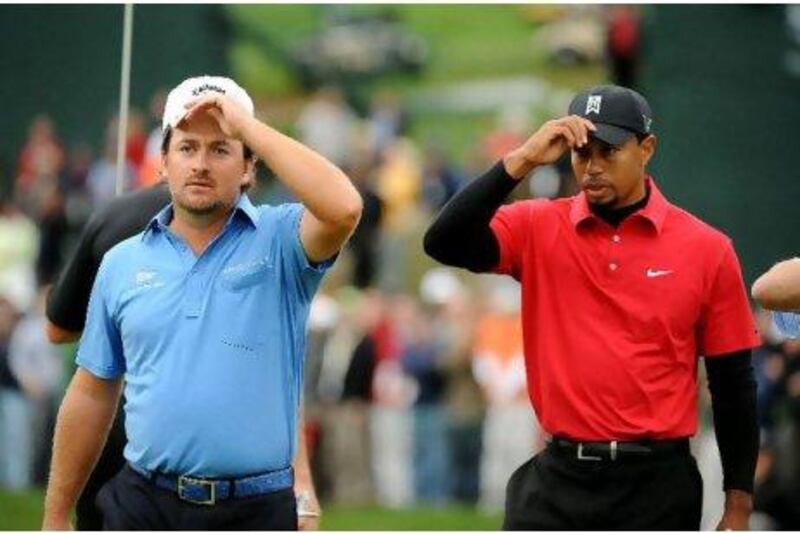 Graeme McDowell, left, and Tiger Woods get serious as they prepare for the sudden-death play-off at the Chevron World Challenge.