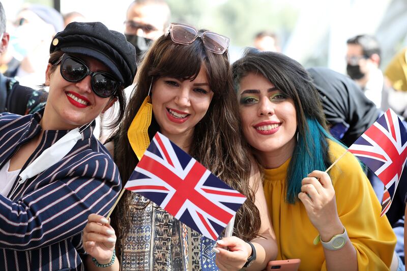 Flags are waved by the crowd.