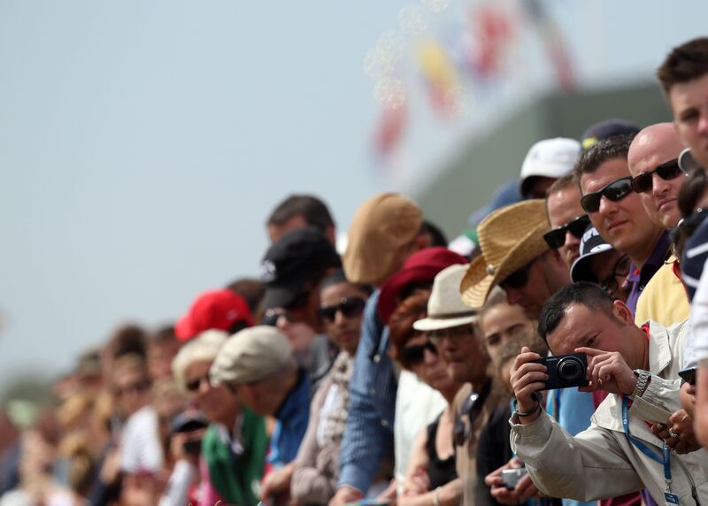 Fans gather around the first tee as US golfer Tiger Woods plays his shot during the fourth and final round of the 2013 British Open Golf Championship at Muirfield golf course at Gullane in Scotland on July 21, 2013. AFP PHOTO/ADRIAN DENNIS
 *** Local Caption ***  589015-01-08.jpg