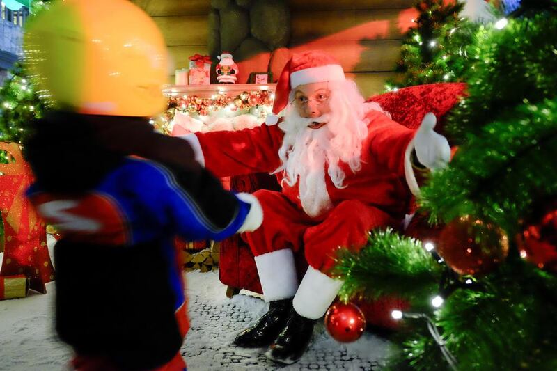 Santa receives a visitor in his wooden hut in Ski Dubai. Antonie Robertson / The National