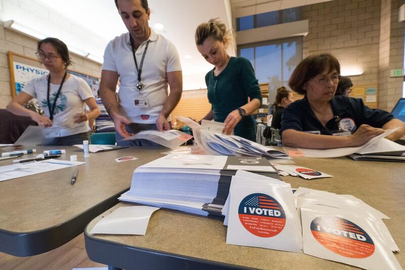 Poll workers help voters at polling station during early voting for the mid-term elections in the Lakeview Terrace neighborhood of Los Angeles, California. AFP