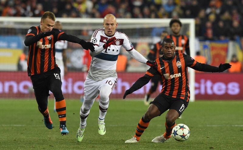 Bayern Munich's Arjen Robben cuts through two Shakhtar players during the Uefa Champions League first leg in Donetsk. Tobia Schwarz / AFP