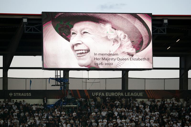The giant screen displays a picture of Queen Elizabeth II as players of Zurich and Arsenal observe a minute's silence before the second half of their Europa League match in St Gallen, Switzerland, on September 8. Getty