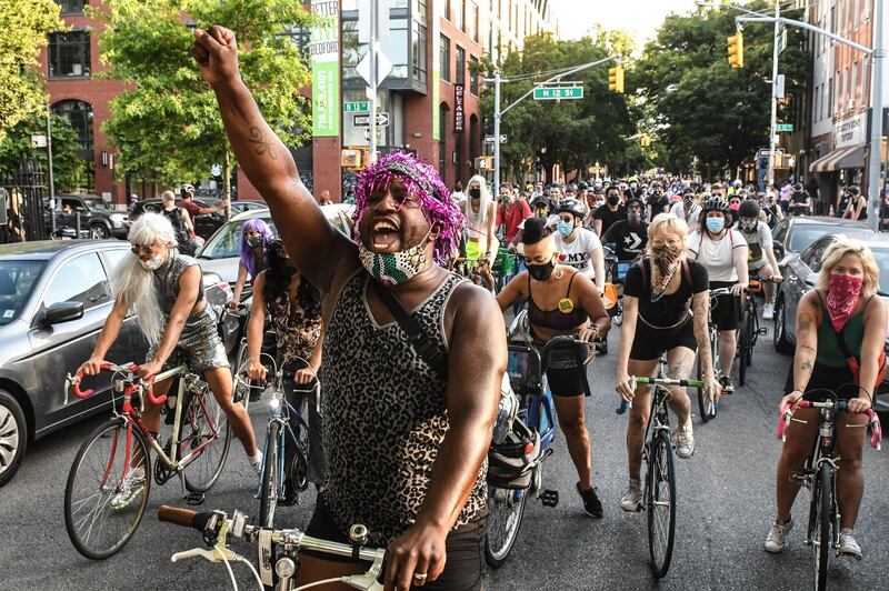 People ride bikes and skateboards during a Black Lives Matter rally in Williamsburg, New York City. AFP