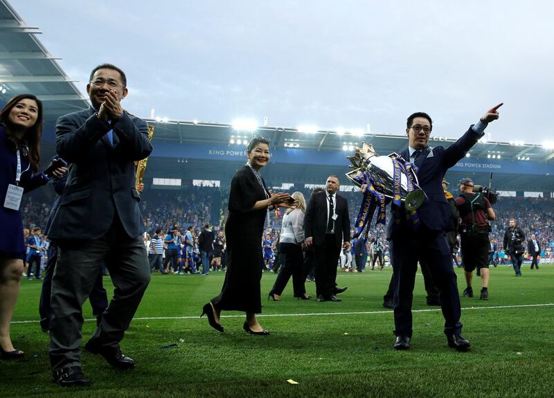 Leicester City's Thai chairman Vichai Srivaddhanaprabha (L) and his son Aiyawatt Srivaddhanaprabha (R) perform a lap of honour with the Premier league trophy after winning the English Premier League football match between Leicester City and Everton at King Power Stadium in Leicester, central England on May 7, 2016. (Photo by ADRIAN DENNIS / AFP) / RESTRICTED TO EDITORIAL USE. No use with unauthorized audio, video, data, fixture lists, club/league logos or 'live' services. Online in-match use limited to 75 images, no video emulation. No use in betting, games or single club/league/player publications. / 