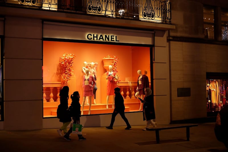 People wearing face masks walk past the temporarily closed Chanel shop on New Bond Street, during England's second coronavirus lockdown in London, Wednesday, Nov. 25, 2020. With major COVID-19 vaccines showing high levels of protection, British officials are cautiously â€” and they stress cautiously â€” optimistic that life may start returning to normal by early April. (AP Photo/Matt Dunham)