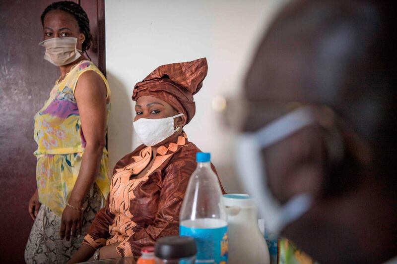 Congolese Eouani Mambia Morelline, 40-year-old head of a collective for migrant women in Morocco, visits her neighbours while wearing a protective mask in the Moroccan capital Rabat.  AFP