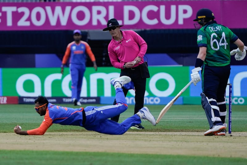 India's Axar Patel dives to take a catch to dismiss Barry McCarthy off his own bowling. AFP
