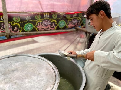 A Hazara youth serves ab-e-lemo to passers-by outside a takyakhana in the Doughabad area of Kabul. Hikmat Noori for The National