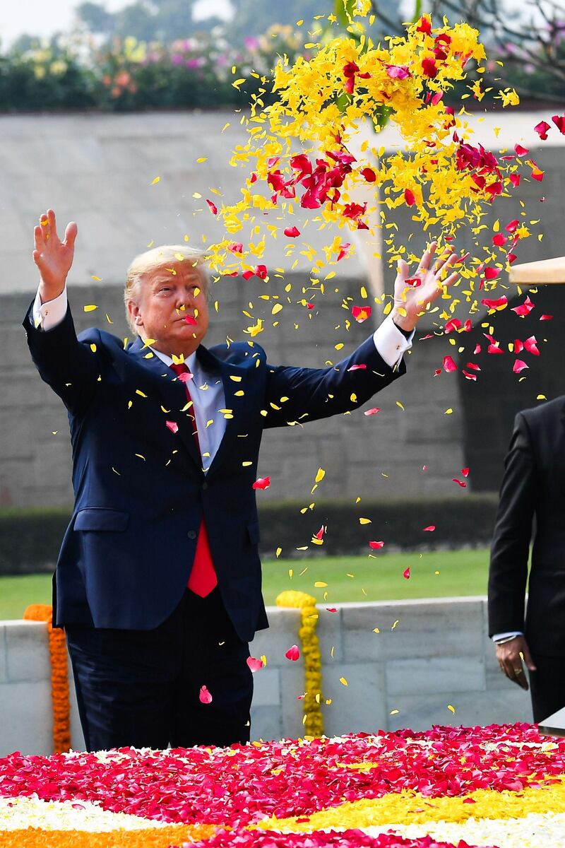US President Donald Trump sprays flower petals to pay tribute at Raj Ghat, the memorial for Indian independence icon Mahatma Gandhi, in New DelhI.  AFP