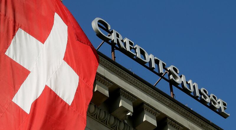 FILE PHOTO: Switzerland's national flag flies next to the logo of Swiss bank Credit Suisse at a branch office in Luzern, Switzerland October 19, 2017.   REUTERS/Arnd Wiegmann/File Photo