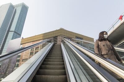 A pedestrian rides an escalator in the Lujiazui Financial District of Shanghai, China, on Monday Feb. 3, 2020. Chinese shares tumbled and the yuan weakened as traders returned from an extended holiday amid the worsening coronavirus outbreak. Photographer: Qilai Shen/Bloomberg