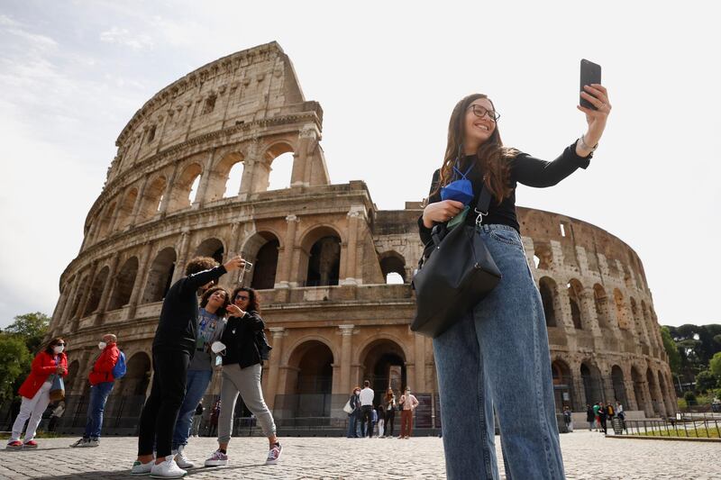 People take selfies outside the Colosseum on the day of its reopening, as much of the country becomes a 'yellow zone', in Rome, Italy. Reuters