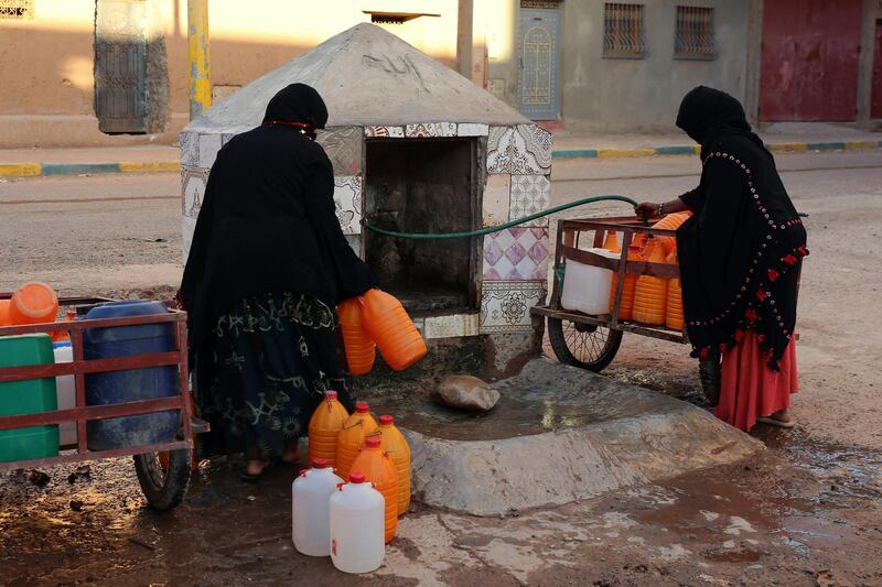 FILE - A Thursday Oct. 19, 2017 file photo of Moroccan women filling up containers with water from a hose, in Zagora, southeastern Morocco. Experts blame poor choices in agriculture, growing populations and climate change for the water shortages in towns like Zagora, which has seen repeated protests for access to clean water in recent weeks. Moroccan state TV channel 2M reports that at least 15 people have died and 5 others have been injured in a stampede Sunday Nov. 19, 2017 as food aid was being distributed in the village of Sidi Boulalam, in the southern province of Essaouira. (AP Photo/Issam Oukhouya, File)