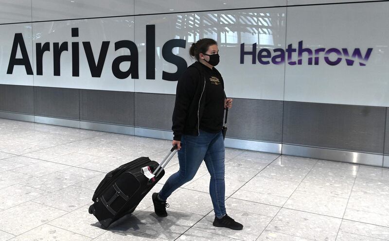 (FILES) In this file photo taken on July 10, 2020 a passenger wearing a face mask or covering due to the COVID-19 pandemic, arrives at Heathrow airport, west London.  Britain's Transport Secretary Grant Shapps set out new rules which, from next week, will require passengers arriving in England by boat, train or plane - including UK nationals - to take a test up to 72 hours before leaving the country of departure.  Failure to comply will lead to an immediate £500 fine. / AFP / DANIEL LEAL-OLIVAS
