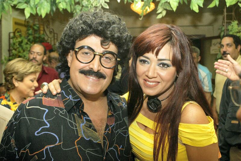 Egyptian comedy star Samir Ghanem poses with actress Rania Yussef (R) on the first day of shooting of a new TV series titled 'Maakom al-Hawa... Hayem Abdel Dayem' in Cairo, late 21 May 2006. The comic musical series, directed by Ashraf Abdel Hadi, will be shown on Egyptian and Arab satellite channels during the holy Muslim month of Ramadan, later this year.   AFP PHOTO/AMRO MARAGHI (Photo by AMRO MARAGHI / AFP)