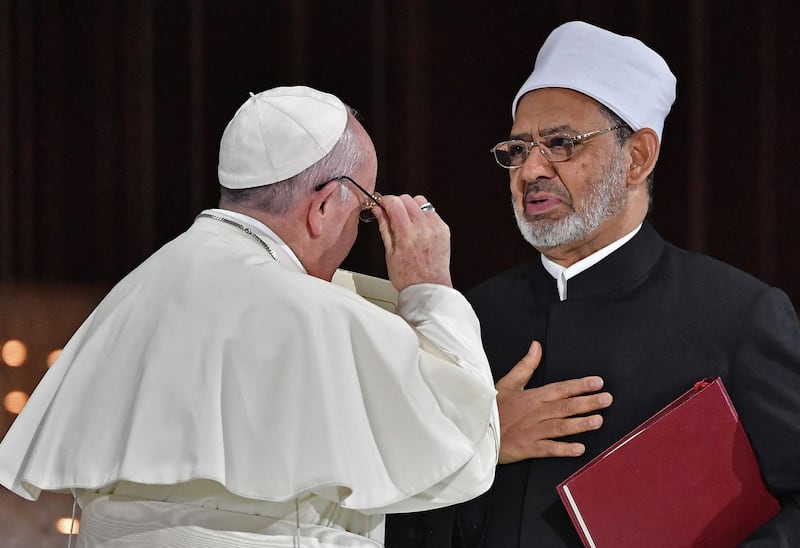 Pope Francis (L) and Egypt's Azhar Grand Imam Sheikh Ahmed al-Tayeb greet each other as they exchange documents during the Human Fraternity Meeting at the Founders Memorial in Abu Dhabi on February 4, 2019. Pope Francis rejected "hatred and violence" in the name of God, on the first visit by the head of the Catholic church to the Muslim-majority Arabian Peninsula. / AFP / Vincenzo PINTO                      
