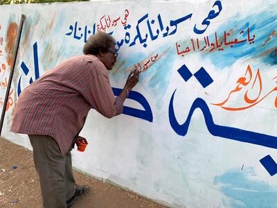 In this April 30, 2019 photo a Sudanese protester is working on a graffiti at the site of a sit-in protest outside the Defence Ministry complex in Khartoum. Photo by Hamza Hendawi for The National.